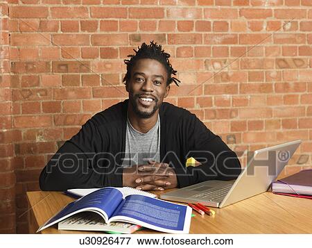 Smiling man studying with laptop View Large Photo Image Stock Photo - Smiling man studying with laptop. Fotosearch