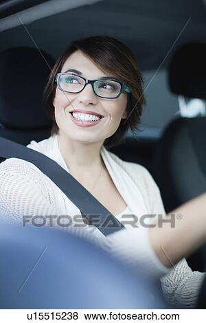 Stock Photo - Smiling woman driving car. Fotosearch