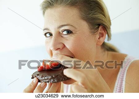 Smiling woman eating cake View Large Photo Image Stock Photo - Smiling woman eating cake. Fotosearch