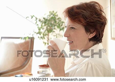 Smiling woman having cup of coffee View Large Photo Image Stock Image - Smiling woman having cup of coffee. Fotosearch