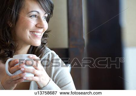 Smiling woman having cup of coffee View Large Photo Image Stock Photo - Smiling woman having cup of coffee. Fotosearch