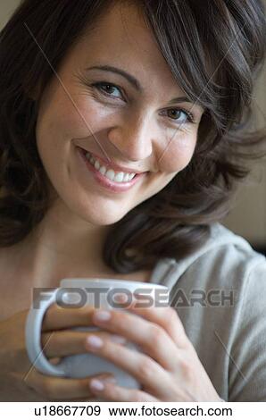 Smiling woman having cup of coffee View Large Photo Image Stock Photo - Smiling woman having cup of coffee. Fotosearch