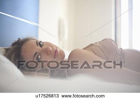 Smiling woman laying on bed View Large Photo Image Stock Image - Smiling woman laying on bed. Fotosearch