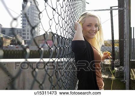 Smiling woman listening to headphones View Large Photo Image Stock Image - Smiling woman listening to headphones. Fotosearch