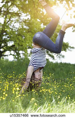 Smiling woman playing in grass View Large Photo Image Stock Photograph - Smiling woman playing in grass. Fotosearch