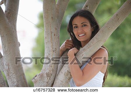 Smiling woman playing in tree View Large Photo Image Stock Photo - Smiling woman playing in tree. Fotosearch