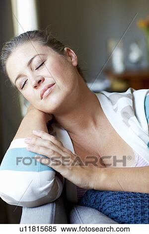 Smiling woman relaxing on sofa View Large Photo Image Stock Photography - Smiling woman relaxing on sofa. Fotosearch