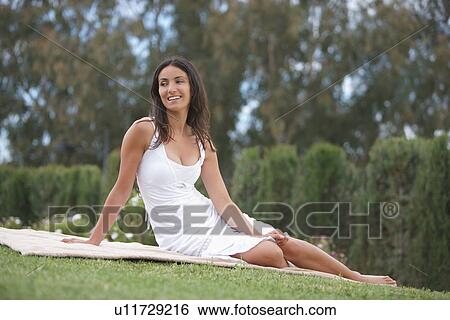 Smiling woman sitting in grass View Large Photo Image Stock Photograph - Smiling woman sitting in grass. Fotosearch