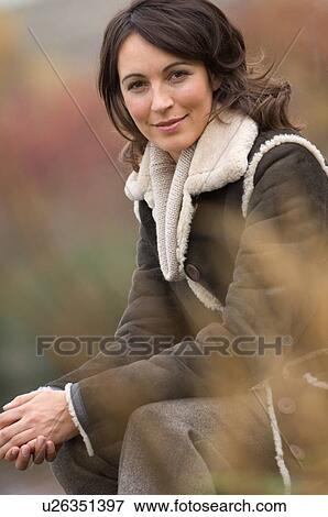 Smiling woman sitting outdoors View Large Photo Image Stock Photo - Smiling woman sitting outdoors. Fotosearch