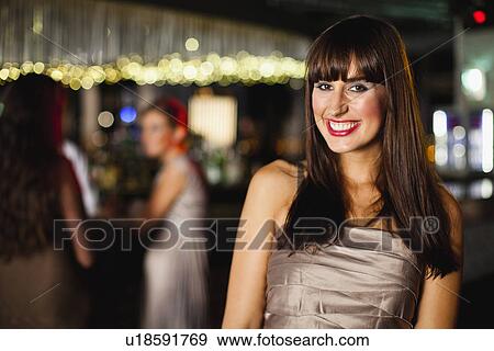 Smiling woman standing in bar View Large Photo Image Stock Photo - Smiling woman standing in bar. Fotosearch