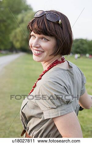 Smiling woman standing in field View Large Photo Image Stock Image - Smiling woman standing in field. Fotosearch