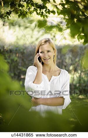 Smiling woman talking on cell phone View Large Photo Image Stock Photography - Smiling woman talking on cell phone. Fotosearch