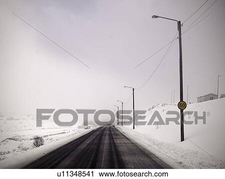 Stock Image - Street lights in snowy landscape. Fotosearch