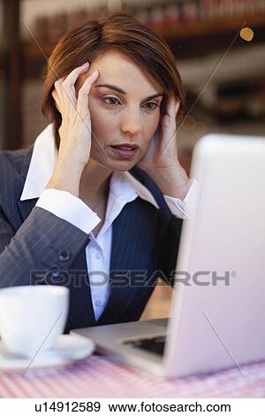 Stock Photo - Stressed businesswoman working in cafe. Fotosearch