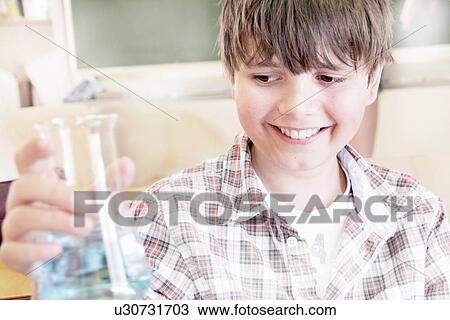 Student examining liquid in beaker View Large Photo Image Stock Image - Student examining liquid in beaker. Fotosearch