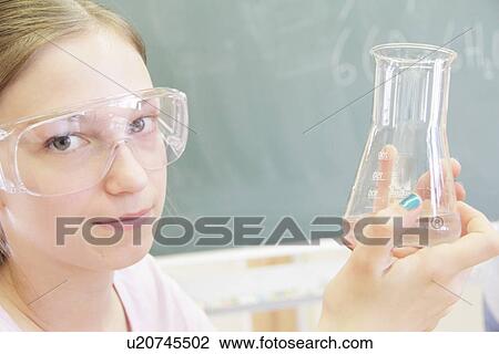 Stock Image - Student examining liquid in test tube. Fotosearch