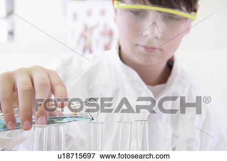 Stock Photo - Student pouring liquid into test tube. Fotosearch