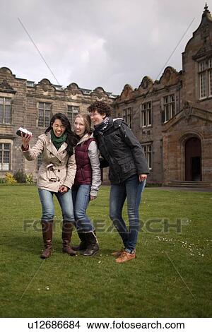 Picture - Students laughing together on campus. Fotosearch