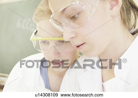 Stock Photo - Students wearing safety goggles in lab. Fotosearch