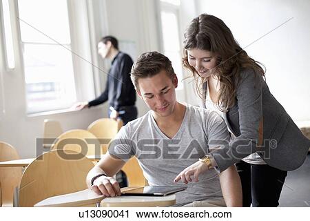 Stock Image - Students working on tablet computer. Fotosearch