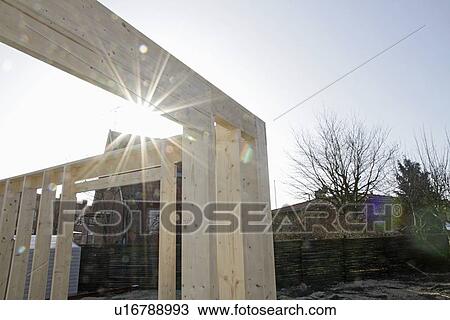 Stock Image - Sun shining on new building on site. Fotosearch