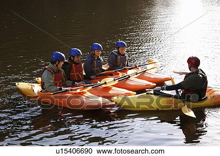 Stock Image - Teacher talking to students in kayaks. Fotosearch