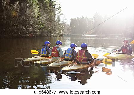 Stock Photo - Teacher talking to students in kayaks. Fotosearch