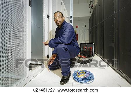 Stock Photo - Technician working in server room. Fotosearch