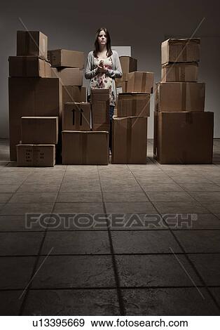 Stock Photo - Teenage girl in pile of cardboard boxes. Fotosearch