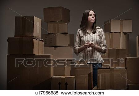 Teenage girl in pile of cardboard boxes View Large Photo Image Stock Photography - Teenage girl in pile of cardboard boxes. Fotosearch