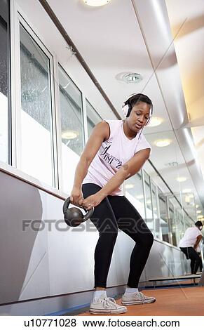 Teenage girl lifting weights in gym View Large Photo Image Stock Photo - Teenage girl lifting weights in gym. Fotosearch