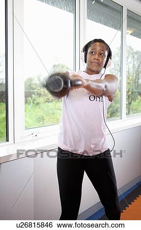 Stock Photograph - Teenage girl lifting weights in gym. Fotosearch