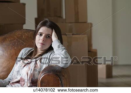 Stock Image - Teenage girl sitting in armchair. Fotosearch