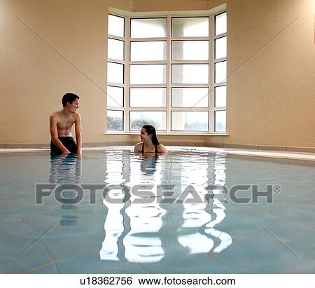 Stock Photograph - Teenagers talking in swimming pool. Fotosearch