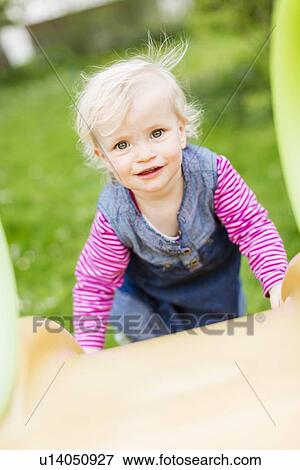 Toddler girl climbing slide in backyard View Large Photo Image Stock Photo - Toddler girl climbing slide in backyard. Fotosearch