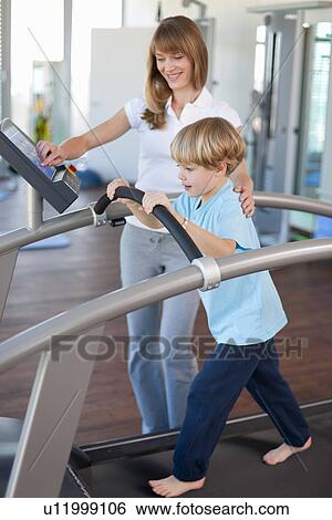 Trainer working with boy in gym View Large Photo Image Stock Photograph - Trainer working with boy in gym. Fotosearch