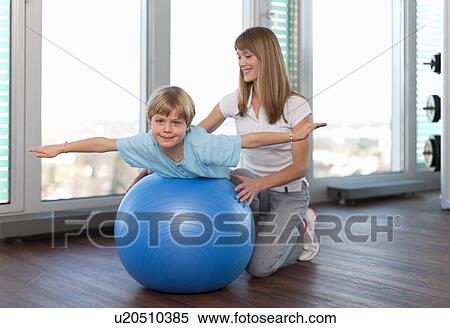 Trainer working with boy in gym View Large Photo Image Stock Photography - Trainer working with boy in gym. Fotosearch