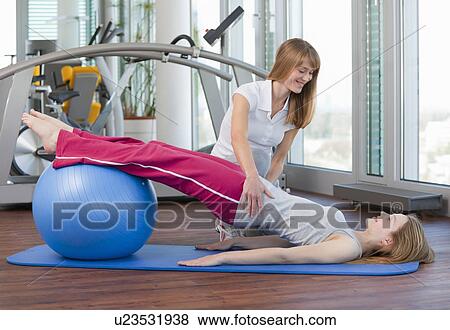 Trainer working with girl in gym View Large Photo Image Stock Photo - Trainer working with girl in gym. Fotosearch