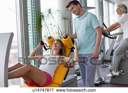 Trainer working with woman in gym View Large Photo Image Stock Photo - Trainer working with woman in gym. Fotosearch