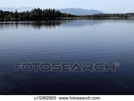 Trees and mountains with still lake View Large Photo Image Stock Photography - Trees and mountains with still lake. Fotosearch