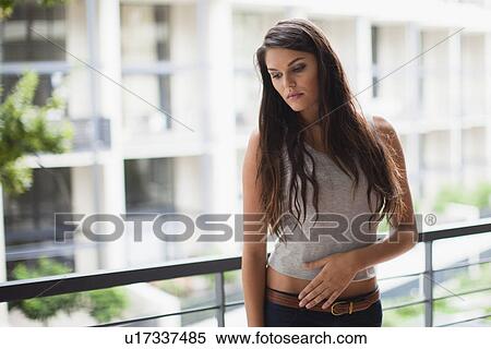 Stock Photography - Upset woman standing on balcony. Fotosearch