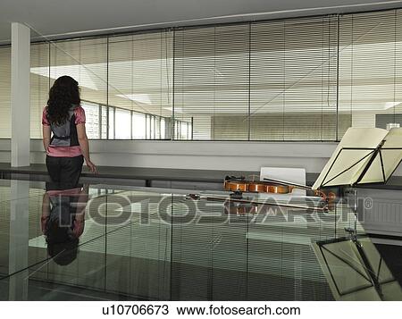 Stock Image - Violin player standing in office. Fotosearch