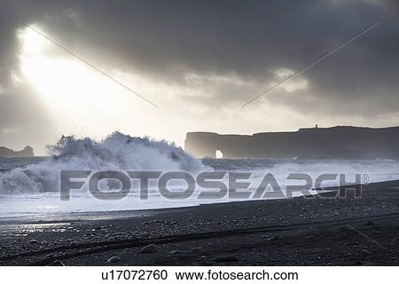 Stock Image - Waves crashing on sandy beach. Fotosearch