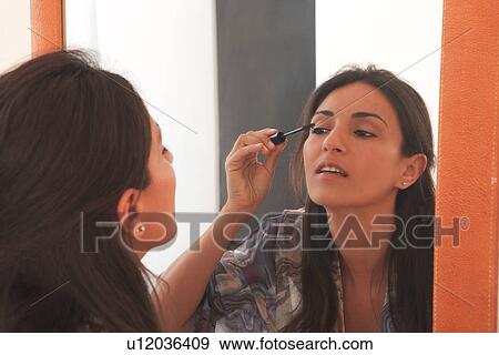 Woman applying makeup in mirror View Large Photo Image Stock Photo - Woman applying makeup in mirror. Fotosearch