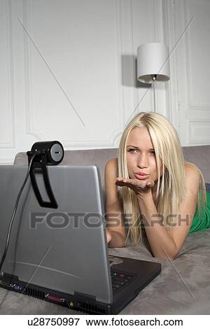 Woman blowing kiss at webcam View Large Photo Image Stock Photo - Woman blowing kiss at webcam. Fotosearch