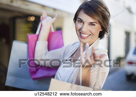 Woman carrying shopping bags outdoors View Large Photo Image Stock Image - Woman carrying shopping bags outdoors. Fotosearch