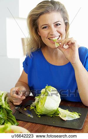 Woman chopping vegetables in kitchen View Large Photo Image Stock Image - Woman chopping vegetables in kitchen. Fotosearch
