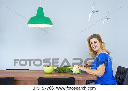 Woman chopping vegetables in kitchen View Large Photo Image Stock Photograph - Woman chopping vegetables in kitchen. Fotosearch