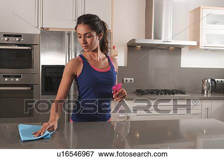 Stock Photo - Woman cleaning kitchen counter. Fotosearch