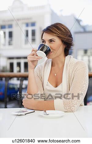 Woman drinking coffee in cafe View Large Photo Image Stock Image - Woman drinking coffee in cafe. Fotosearch
